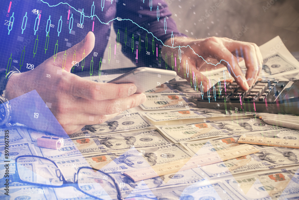 Double exposure of man's hands holding and using a digital device and forex graph drawing. Financial market concept.