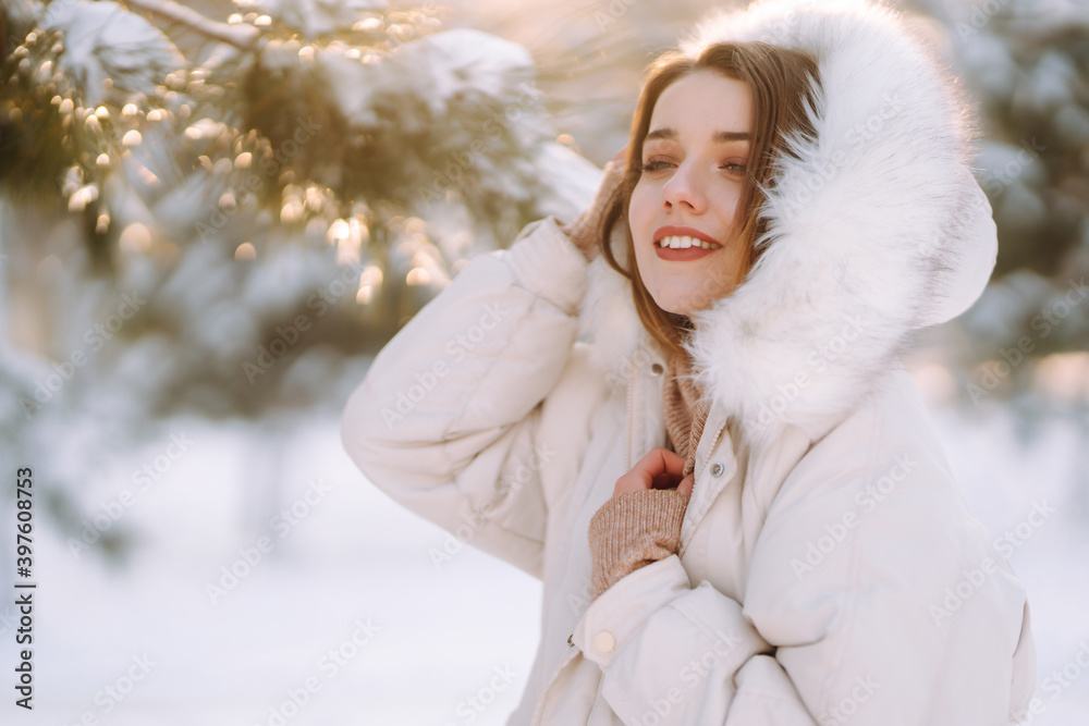 Young beautiful woman posing in a snowy park. Cold weather. Winter fashion, holidays, rest, travel concept. Young beautiful woman posing in a snowy park. Cold weather. Winter fashion, holidays, rest, travel concept.