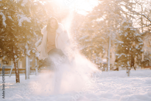 Young beautiful woman  posing in a snowy park. Cold weather. Winter fashion  holidays  rest  travel concept.