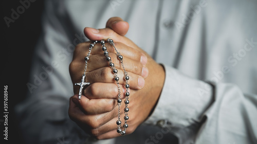 christianity background of man hand holding rosary praying for god blessing