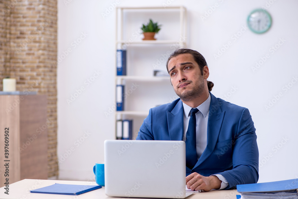 Young male employee working at workplace