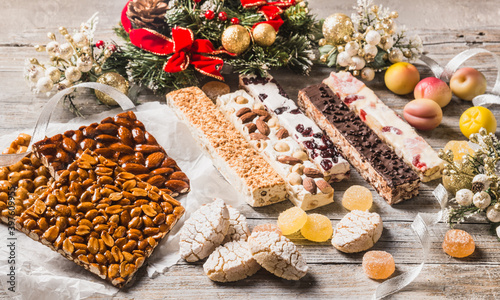 Italian Christmas sweets as different nougats with almonds, nuts, peanuts, candied fruits, marzipan background. Traditional Italian Christmas sweets. photo