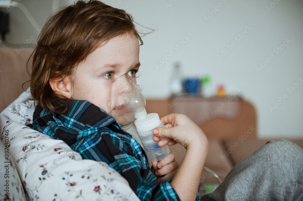A cute boy have a problem with chest coughing holding inhaler mask, Child using the volumtic for breathing treatment, Healthcare and medicine concept. A cute boy have a problem with chest coughing holding inhaler mask, Child using the volumtic for breathing treatment, Healthcare and medicine concept.