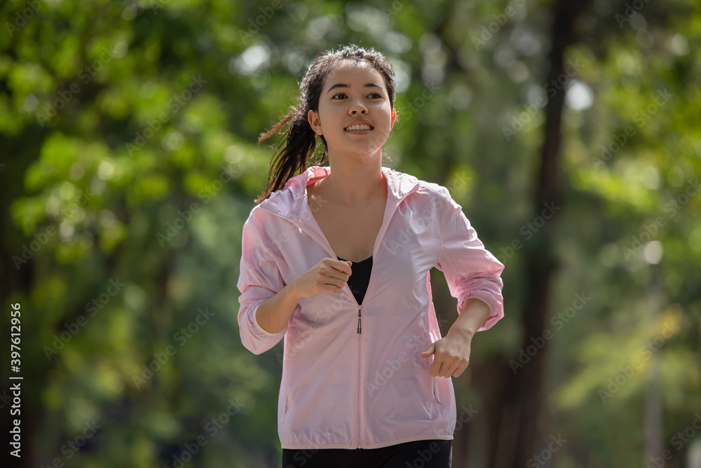 Sporty young Asian runner woman running in park Sporty young Asian runner woman running in park