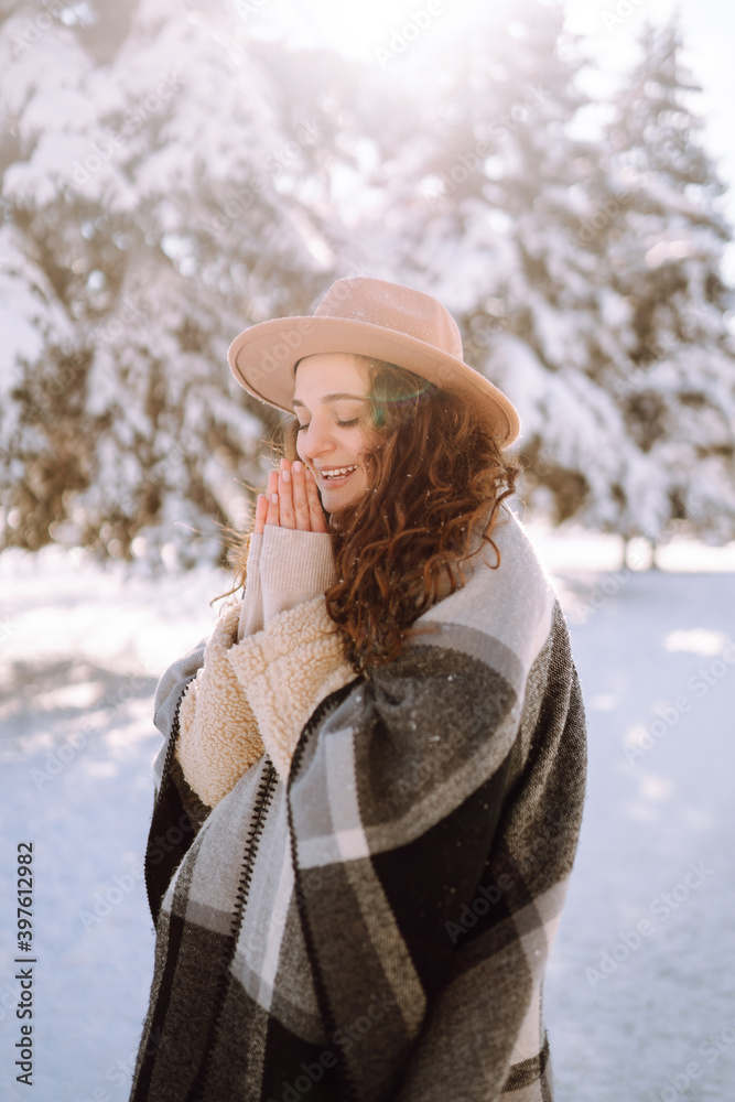 Fototapeta premium Young woman enjoying winter weather in the snow forest. Cold weather. Winter fashion, holidays, rest, travel concept.