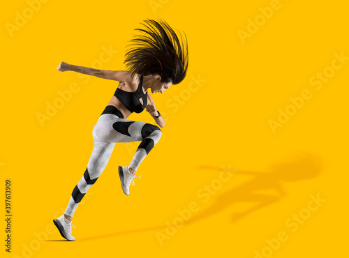 Sporty woman running on isolated on yellow background