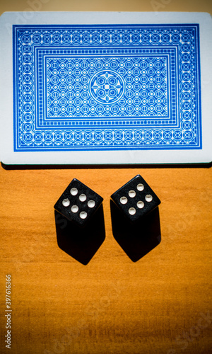 A deck of playing cards and two dice are on the Table.