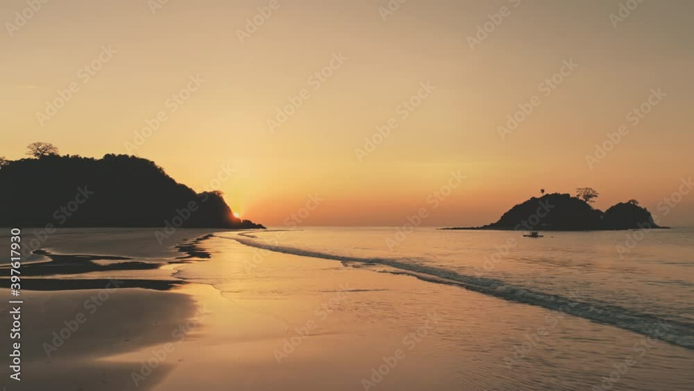 Sunset silhouette of mountains islands at sea bay. Tropic seascape at sand beach. Nobody nature landscape of ocean sandy shore. El Nido Isle, Philippines, Asia at summer evening. Soft drone shot Sunset silhouette of mountains islands at sea bay. Tropic seascape at sand beach. Nobody nature landscape of ocean sandy shore. El Nido Isle, Philippines, Asia at summer evening. Soft drone shot