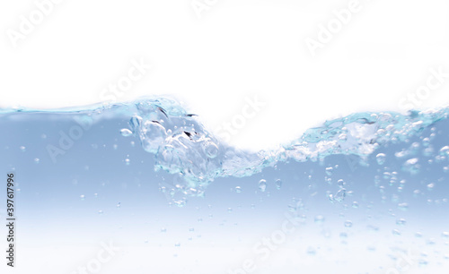 A photograph of a moving water wave with a small amount of bubbles. Where the water is blue and the backdrop is white