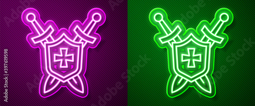 Glowing neon line Medieval shield with crossed swords icon isolated on purple and green background. Vector.