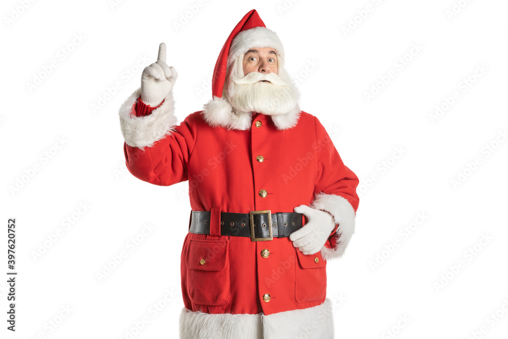 Portrait of a real Santa Claus standing and pointing his finger up at copy space, isolated on white background.