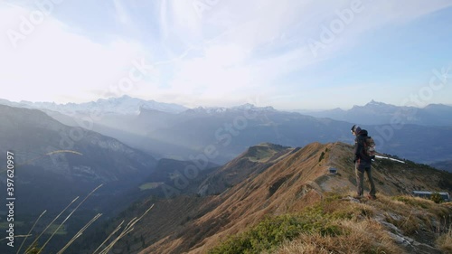 A man is looking at the view from the top of a mountain in autumn photo