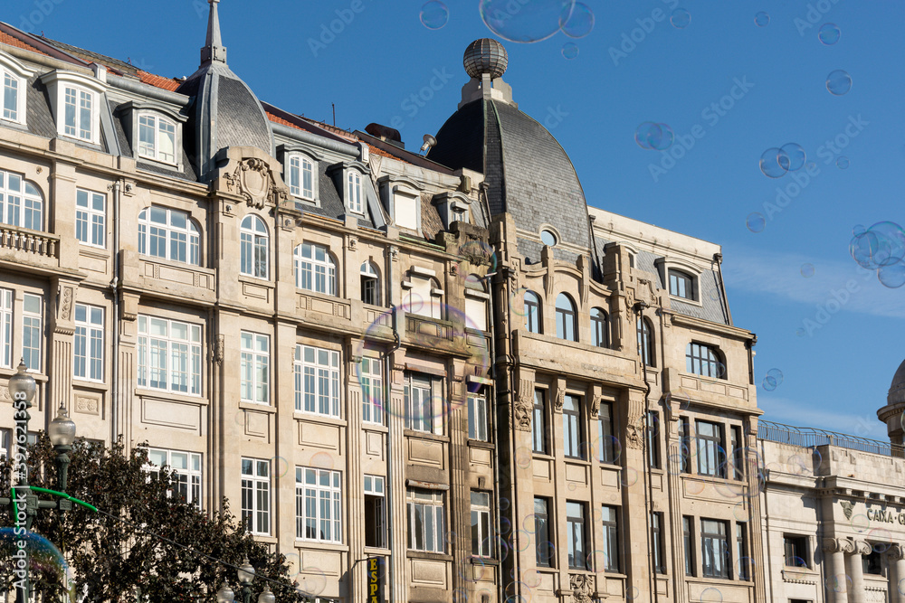 Fototapeta premium Porto, Portugal - 08/28/2019: Big soap bubbles and Porto city in the background. Aliados Avenue.