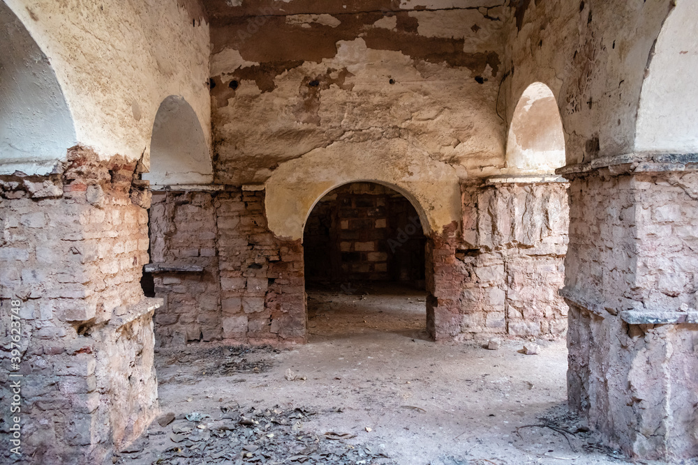Bhopal, Madhya Pradesh, India - March 2019: Dilapidated columns inside an arcaded hall inside an ancient ruined building in the old city of Bhopal.