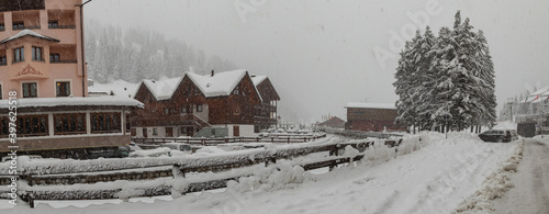 Panorama of river Torrente Frigidolfo in the village of Santa Caterina in heavy snowfall. Visible hotels and houses with some snow flakes falling down. photo