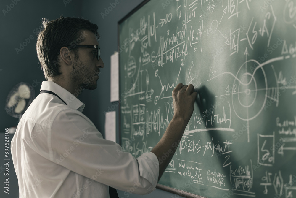 Young smart mathematician drawing on the chalkboard - obrazy, fototapety, plakaty 