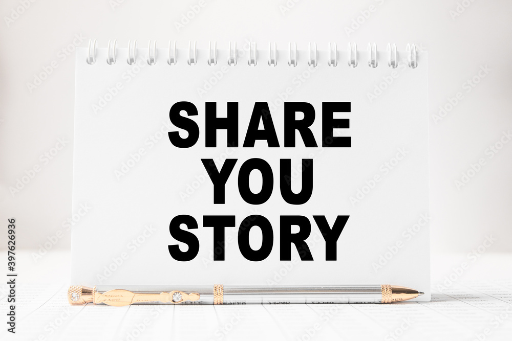 Notepad with inscriptions SHARE YOU STORY on a white background. business concept. Notepad with inscriptions SHARE YOU STORY on a white background. business concept.