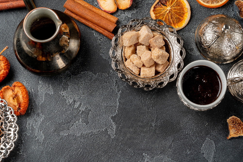 Turkish coffee, turk and sugar on black textured background