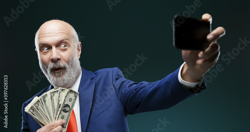Schilderij op canvas Businessman taking a selfie while holding cash money