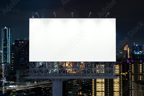 Blank white road billboard with KL cityscape background at night time. Street advertising poster, mock up, 3D rendering. Front view. The concept of marketing communication to promote or sell idea.