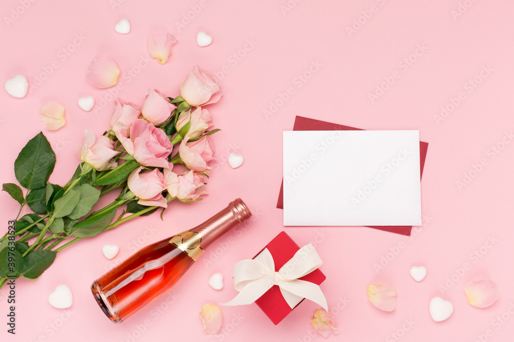 Roses, bottle of wine, empty envelope and gift on pink background. Valentines day concept. Flat lay, top view, copy space. Roses, bottle of wine, empty envelope and gift on pink background. Valentines day concept. Flat lay, top view, copy space.