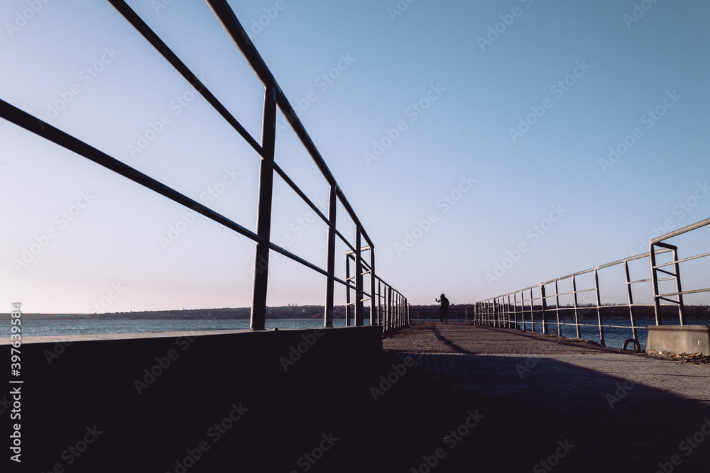 silhouette of person walking on bridge