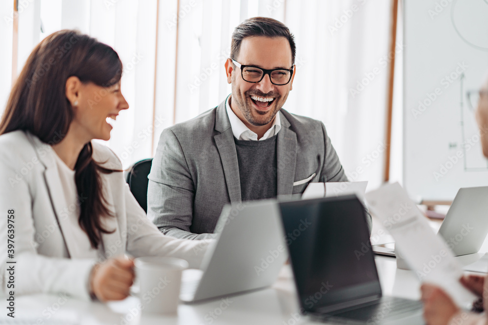 Businessman laughing at the meeting with colleagues Businessman laughing at the meeting with colleagues