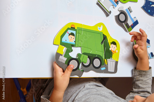 Fototapeta Naklejka Na Ścianę i Meble -  Child playing with puzzles,. The boy is playing in his room. Educational logic toys for kid's..