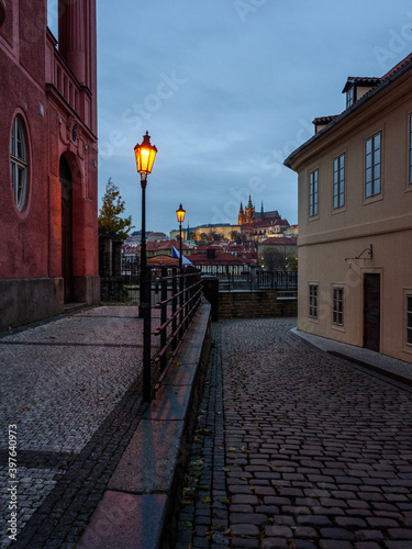 Historic street in Prague's city center with the view on Prague Castle in the evening