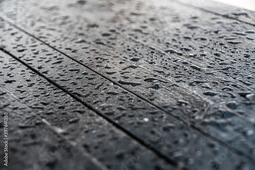 Water drops on black surface of wooden table