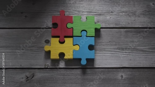 Business people team sitting around meeting table and assembling color jigsaw puzzle pieces unity cooperation ideas concept