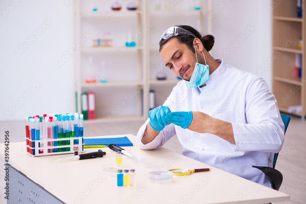 Young male chemist working in the lab Young male chemist working in the lab