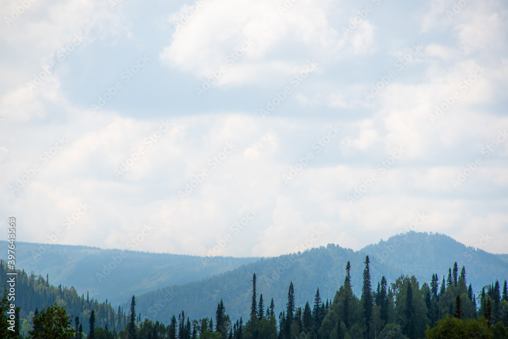 Rocky ridge on horizon under blue cloudy sky. Mountain valley for travel. Adventure travel, tourism and conservation concept. Rocky ridge on horizon under blue cloudy sky. Mountain valley for travel. Adventure travel, tourism and conservation concept.