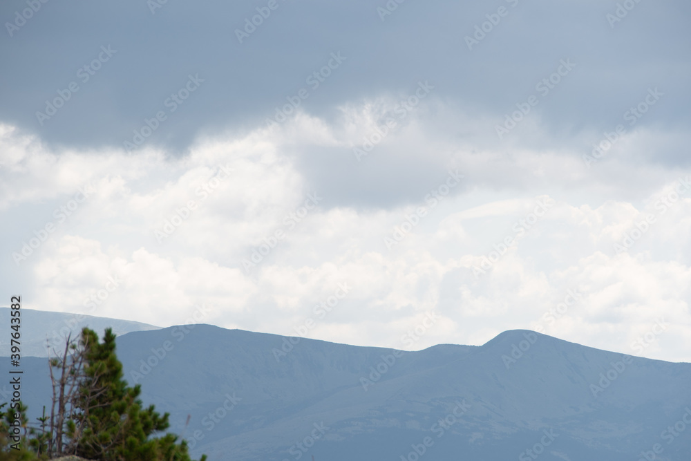 Fototapeta premium View of calming mountain valley with ridge on horizon. Gentle hills in blue haze.