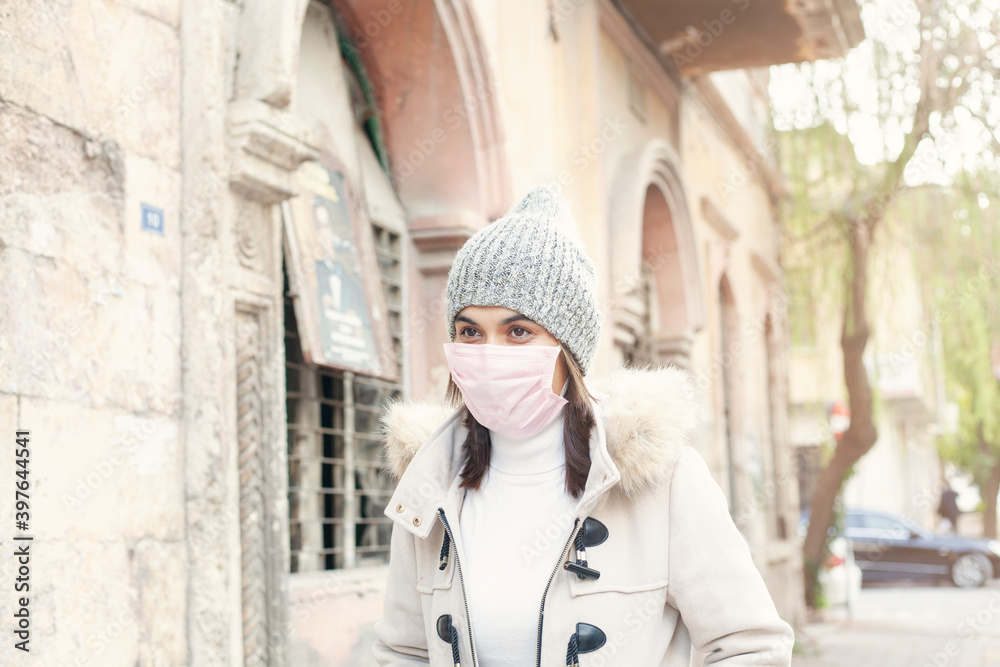 Obraz premium Young woman wearing a mask on street. 