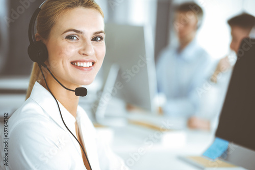 Wallpaper Mural Blonde business woman using headset for communication and consulting people at customer service office. Call center. Group of operators at work Torontodigital.ca