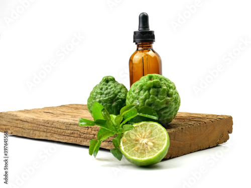 Herbs, bergamot essential oil and fruit on wood background, isolated on white background.