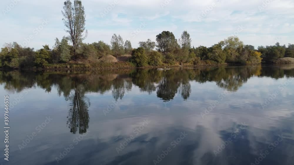 Smooth drone shot close to the water's surface, following a kayaker from a distance. Smooth drone shot close to the water's surface, following a kayaker from a distance.