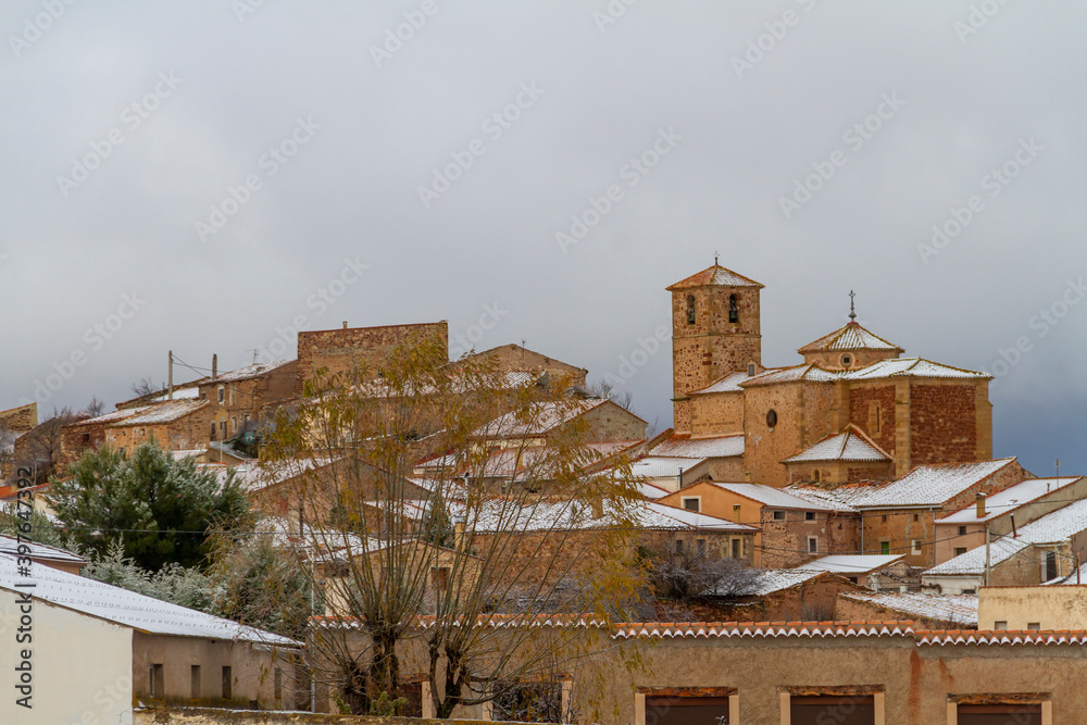 View of the Castellar de la Muela snowy town in the province of Guadalajara, Molina-Alto Tajo county, with the tower of the Church of N.ª S.ª de la Carrasca in the center