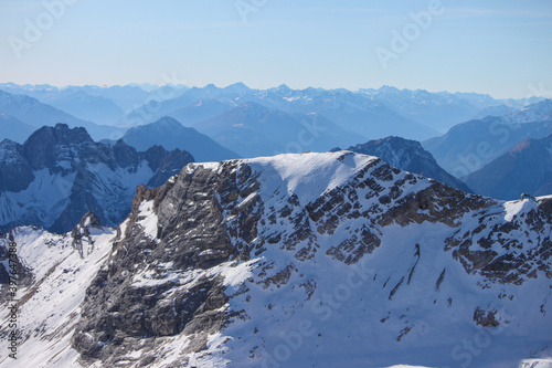 Top of Germany  A large view to the snow coverered and rocky mountain ranges of the Alps from the glacier of the highest german mountain Zugspitze on a beautiful sunny day 