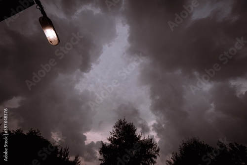 dark cloudy sky with a lamp and some trees