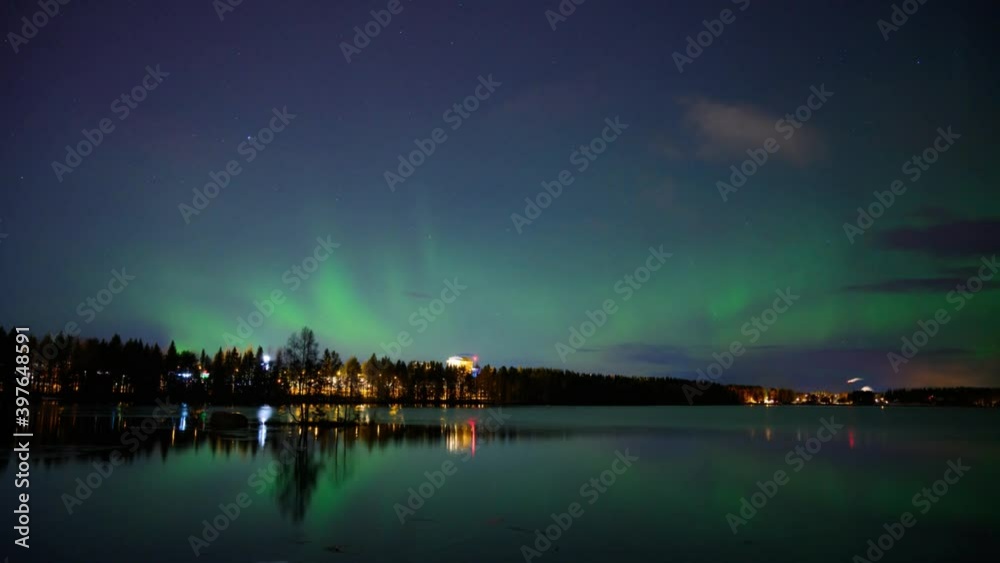 A 4k HD time-lapse of northern light dancing over a half-frozen lake and cloudy dark sky with reflection from the water A 4k HD time-lapse of northern light dancing over a half-frozen lake and cloudy dark sky with reflection from the water