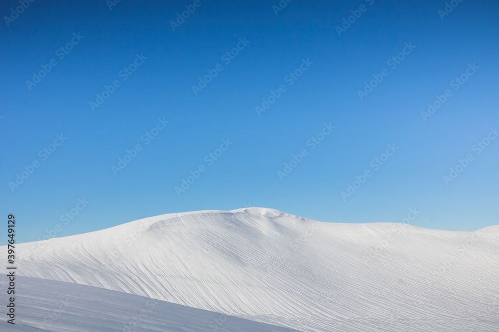 Dune de neige au sommet d'une montagne sous un beau ciel bleu