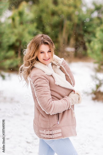 young smiling woman in pink clothes in a winter forest