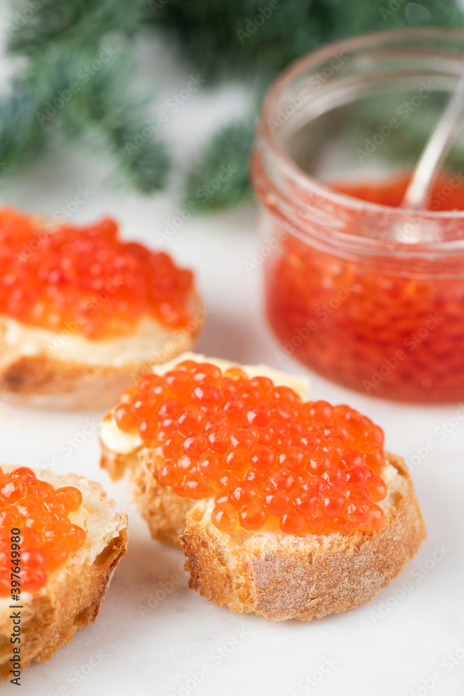 Canape toast with red caviar on white background. Closeup view. Luxury appetizer