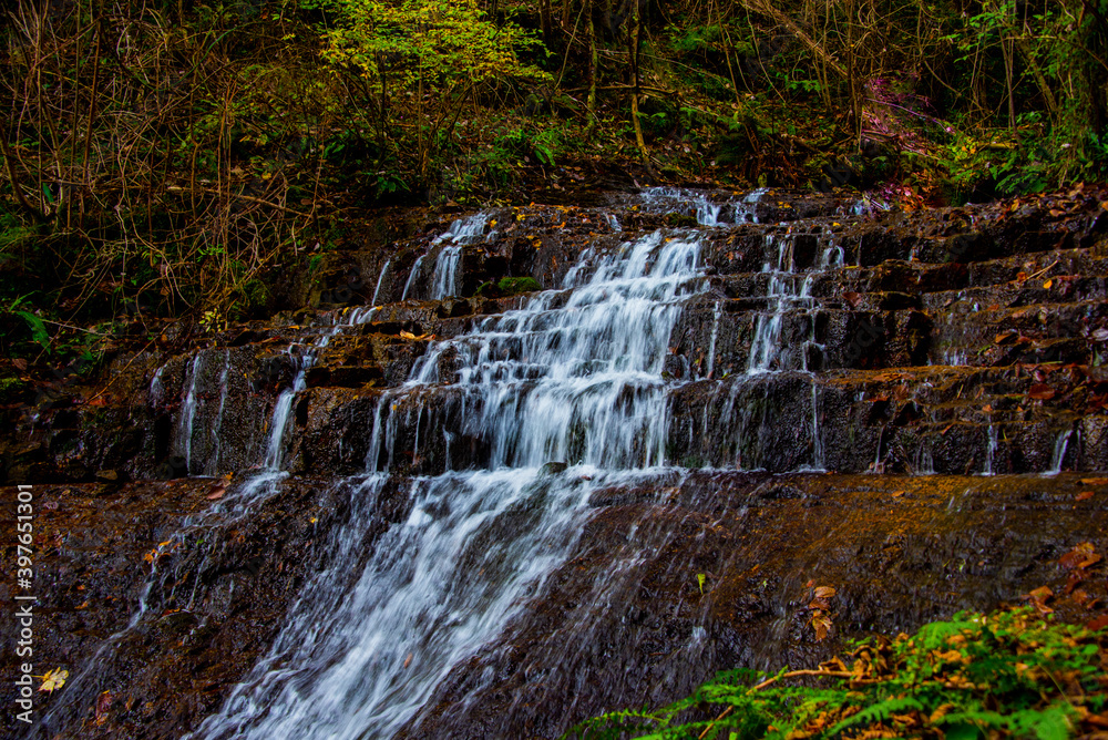 Fototapeta premium alpine waterfall in the autumn woods