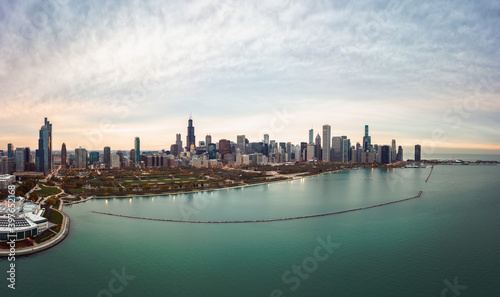 Wide angle Chicago city skyline aerial panorama with Lake Michigan in the foreground overlooking Grant Park and highrise skyscraper buildings with a beautiful orange and blue sunset sky above. © Joseph Kirsch