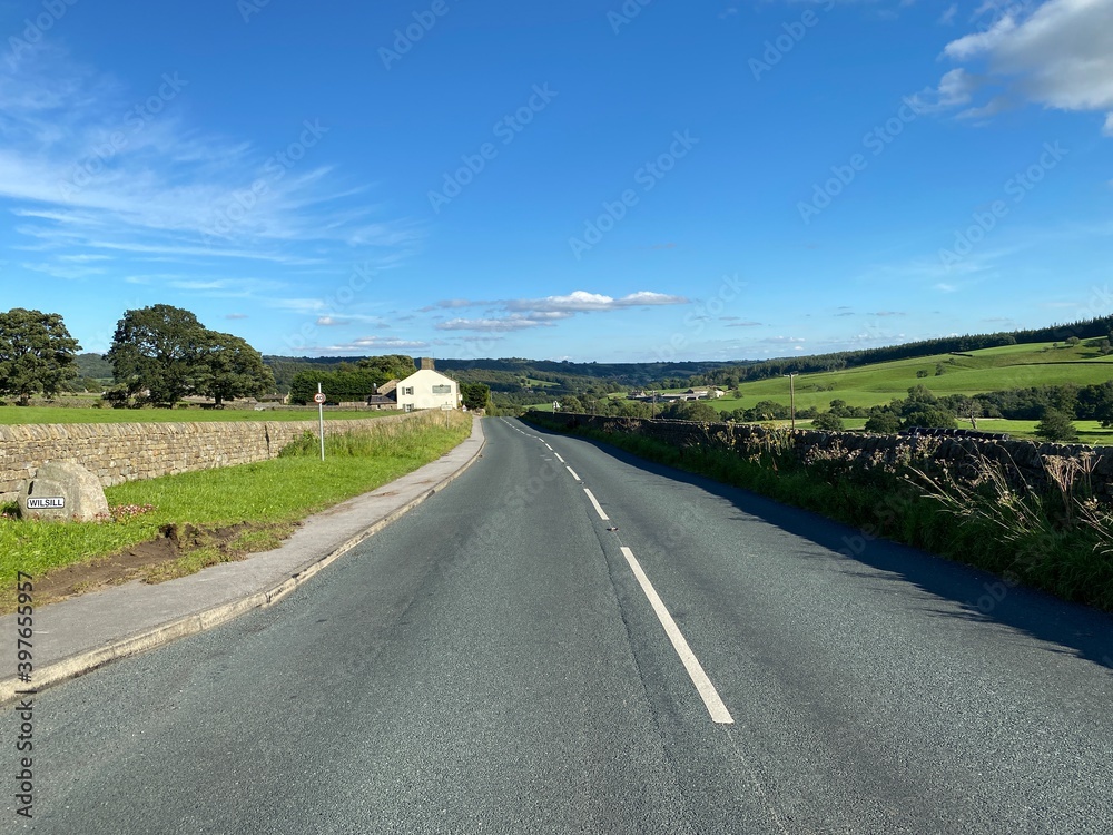 Lupton Bank road, as it passes through the village of, Wilsill, on a hot summers day in, Glasshouses, Pateley Bridge, UK