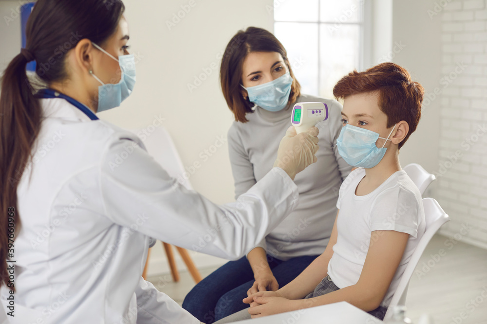 Family doctor measuring little boy's temperature with non-contact digital thermometer Family doctor measuring little boy's temperature with non-contact digital thermometer