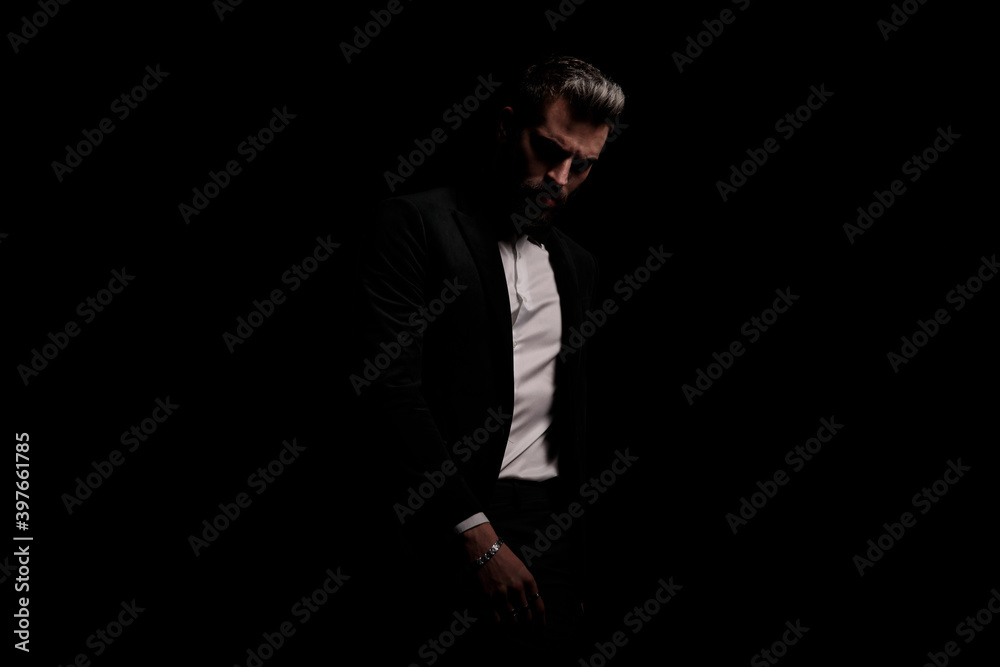 mysterious businessman in black velvet tuxedo posing